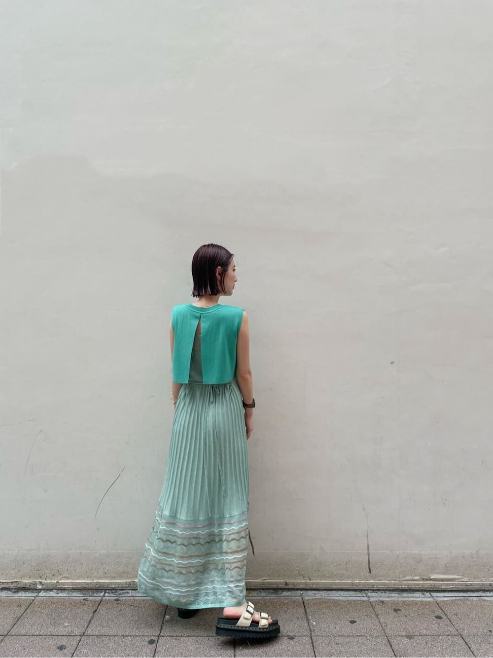 グリーン系のワンピース、ベージュ系のサンダルを着用したレディースの夏コーディネートの3枚目の写真