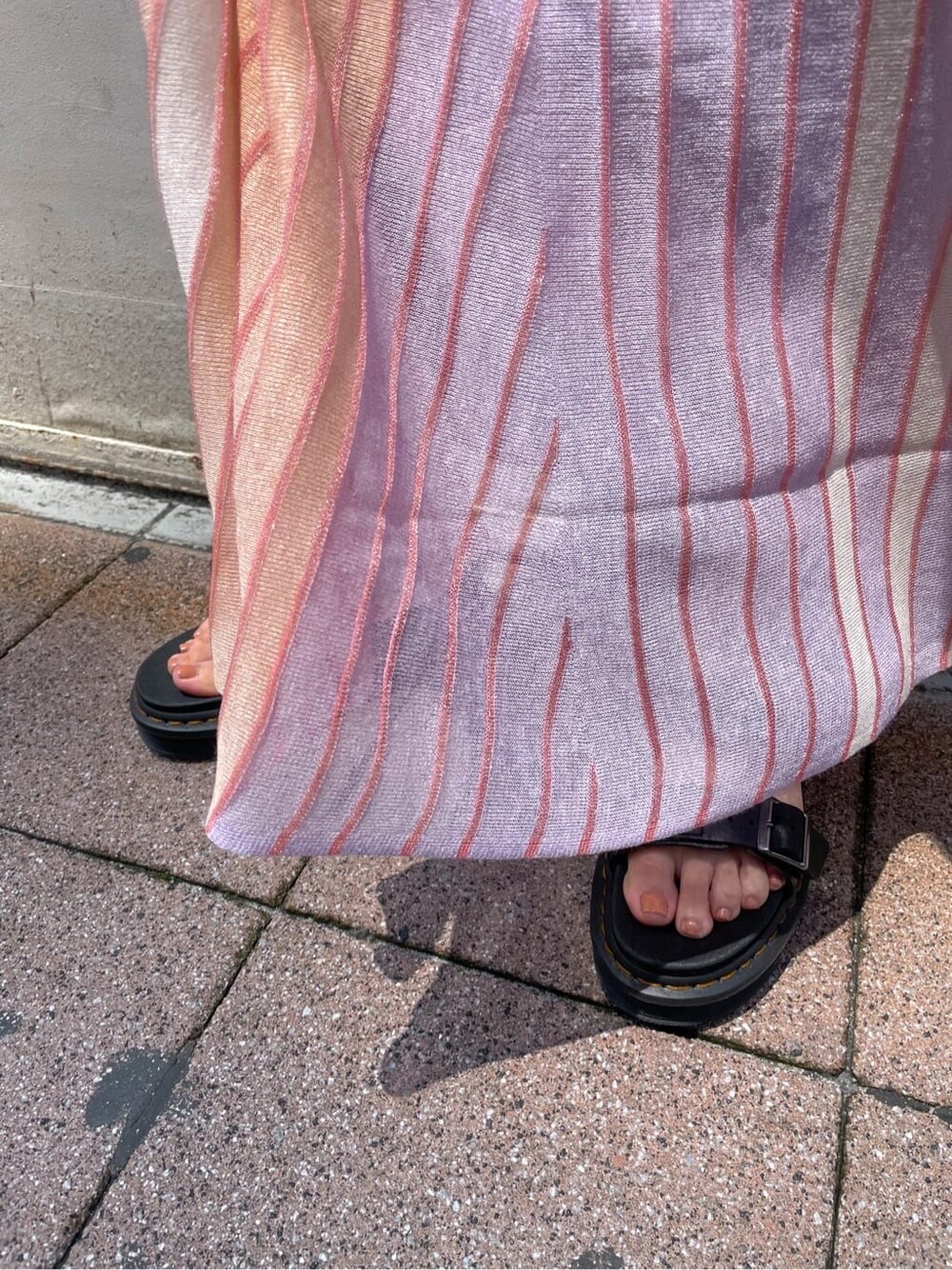 オレンジ系のワンピース、ブラック系のその他シューズを着用したレディースの夏コーディネートの8枚目の写真