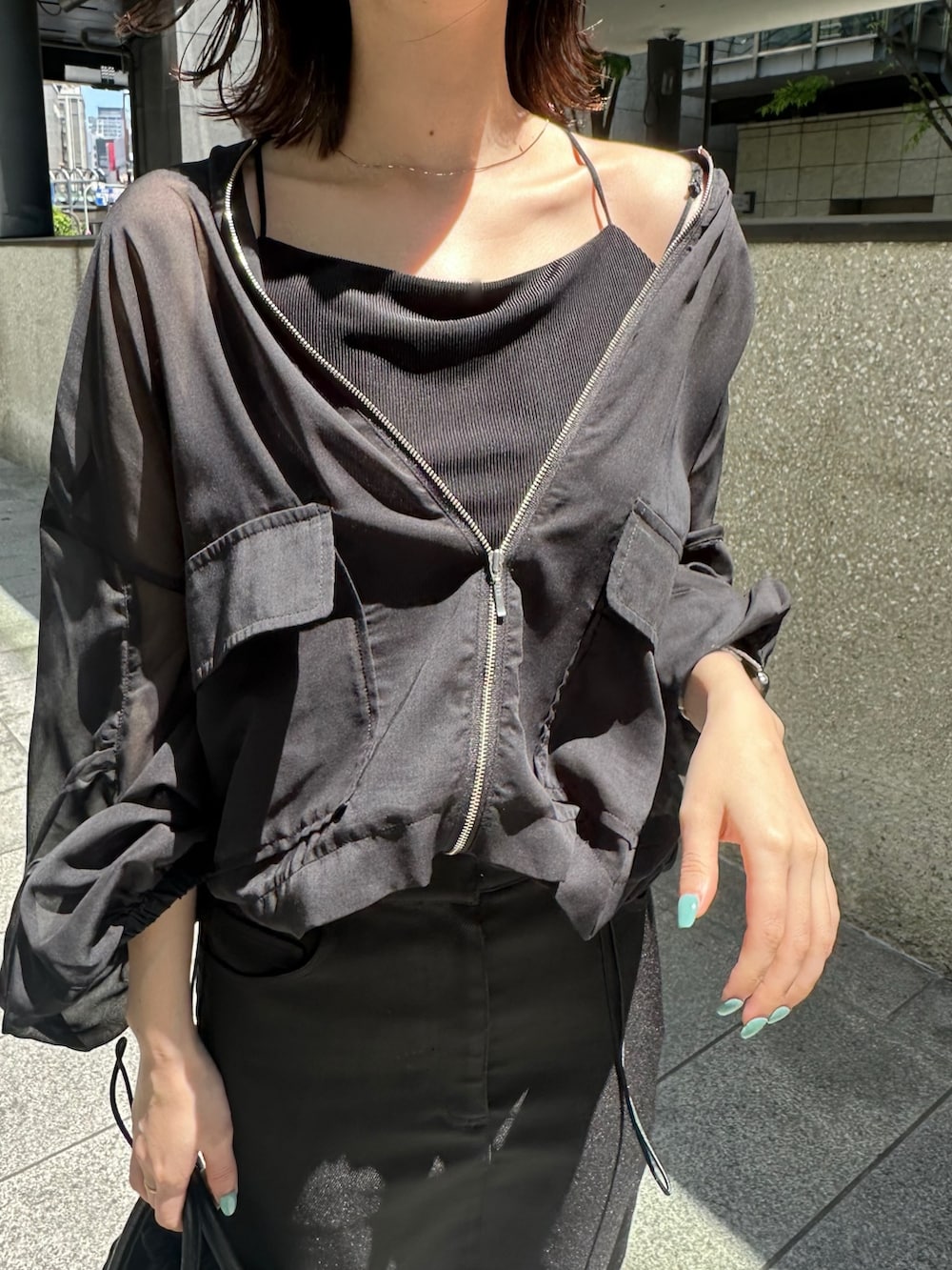 ブラック系のキャミソール、ブラック系のノーカラージャケット、シルバー系のパンプスを着用したレディースの春コーディネートの6枚目の写真