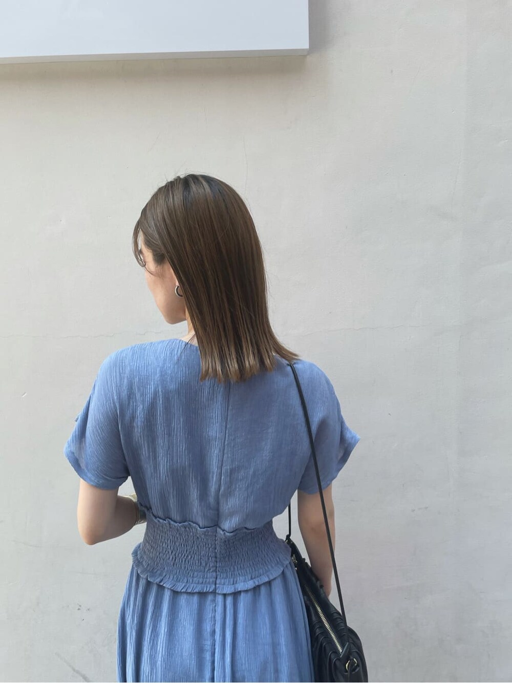 ブラック系のハンドバッグ、ブラック系のサンダル、ブルー系のワンピースを着用したレディースの夏コーディネートの4枚目の写真