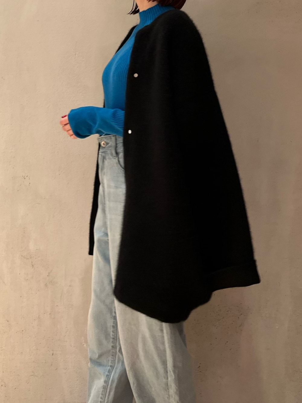 ブラック系のノーカラージャケット、ブルー系のニット/セーター、ブルー系のデニムパンツを着用したレディースの夏コーディネートの5枚目の写真