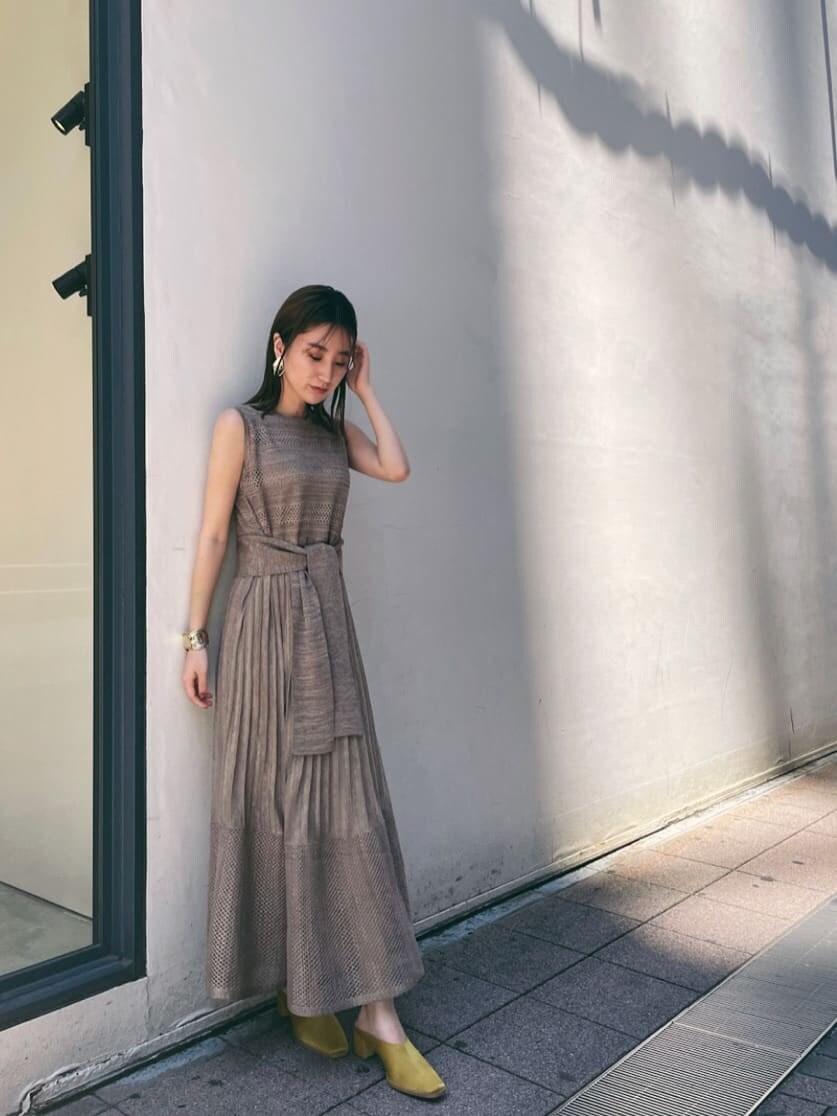 ブラウン系のカーディガン/ボレロ、ベージュ系のワンピース、イエロー系のスリッポンを着用したレディースの夏コーディネートの2枚目の写真