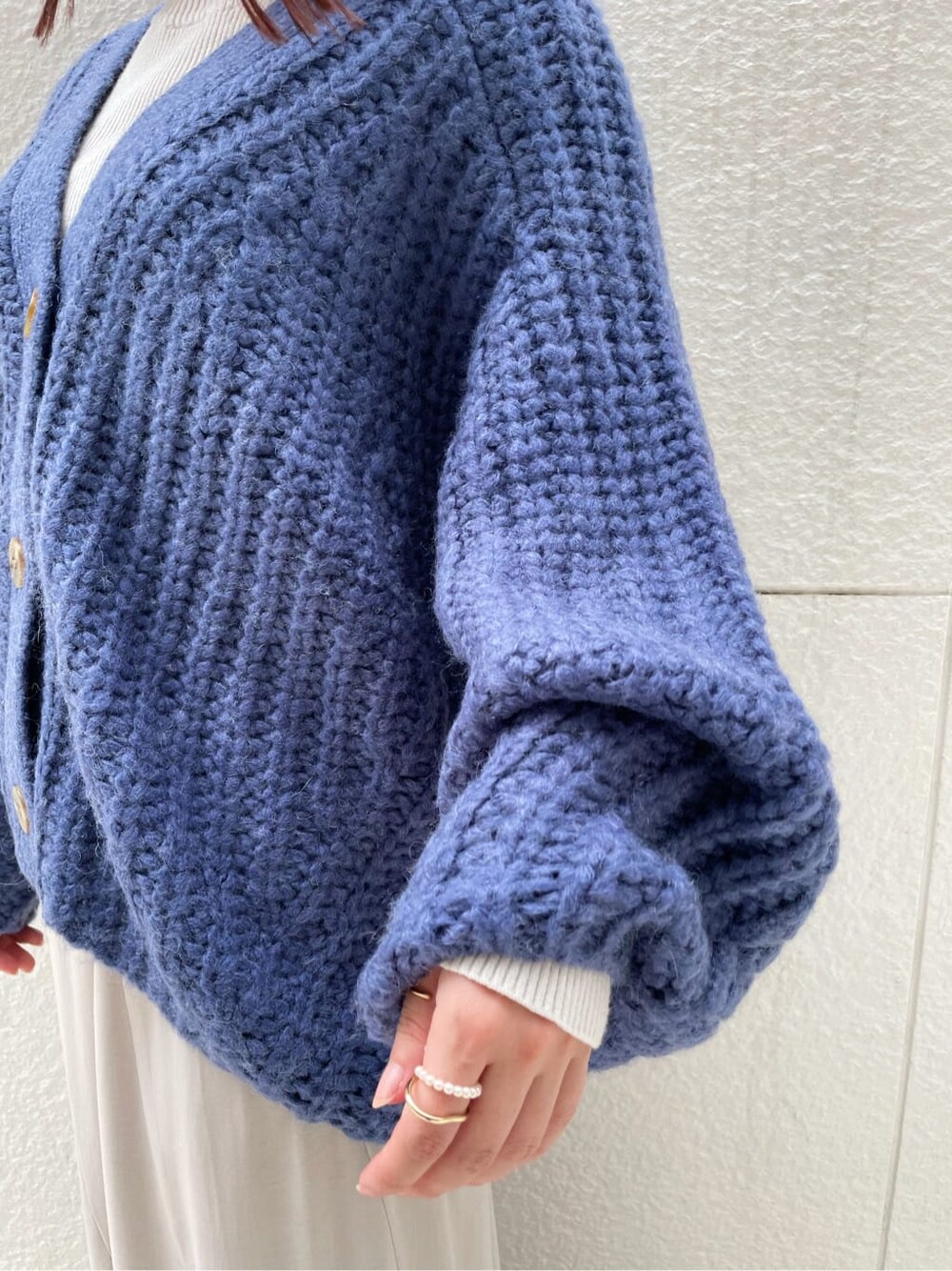 グレー系のニット/セーター、グレー系のスカート、ブラック系のその他シューズを着用したレディースの秋コーディネートの5枚目の写真