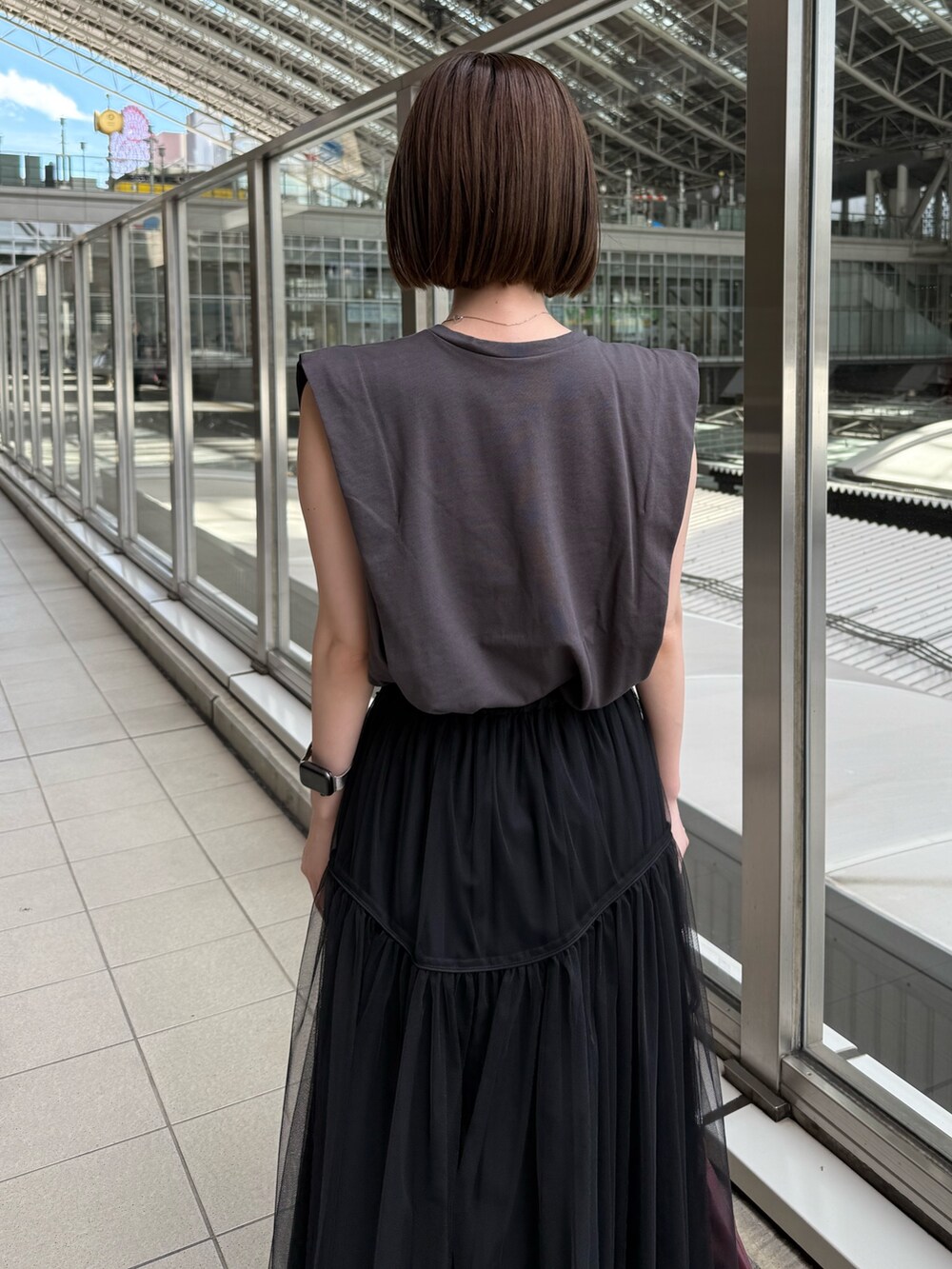 グレー系のTシャツ/カットソー、ブラック系のスカート、レッド系のショルダーバッグを着用したレディースの夏コーディネートの8枚目の写真