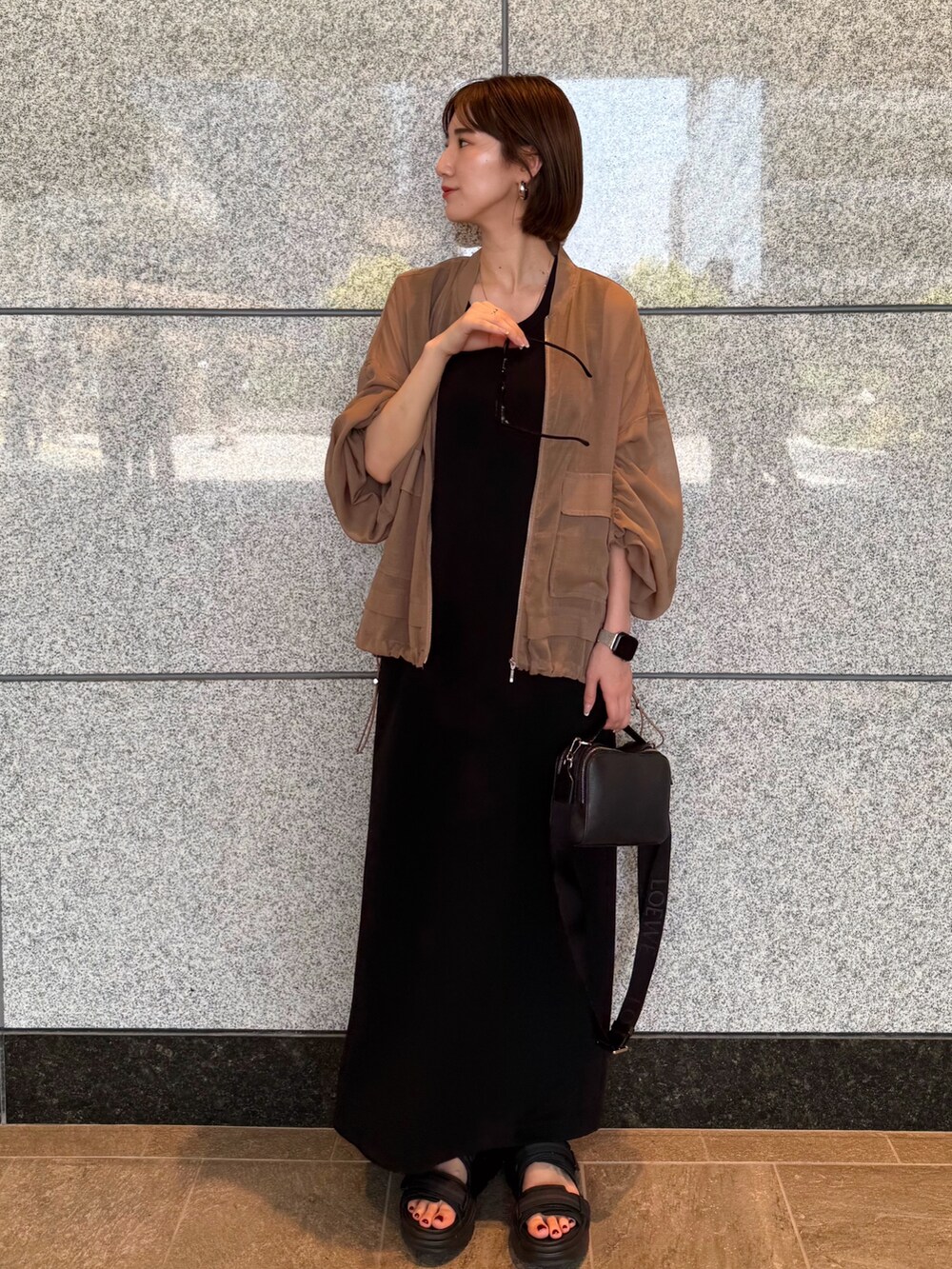 ベージュ系のブルゾン、ブラック系のワンピース、ブラック系のサングラスを着用したレディースの夏コーディネートの6枚目の写真