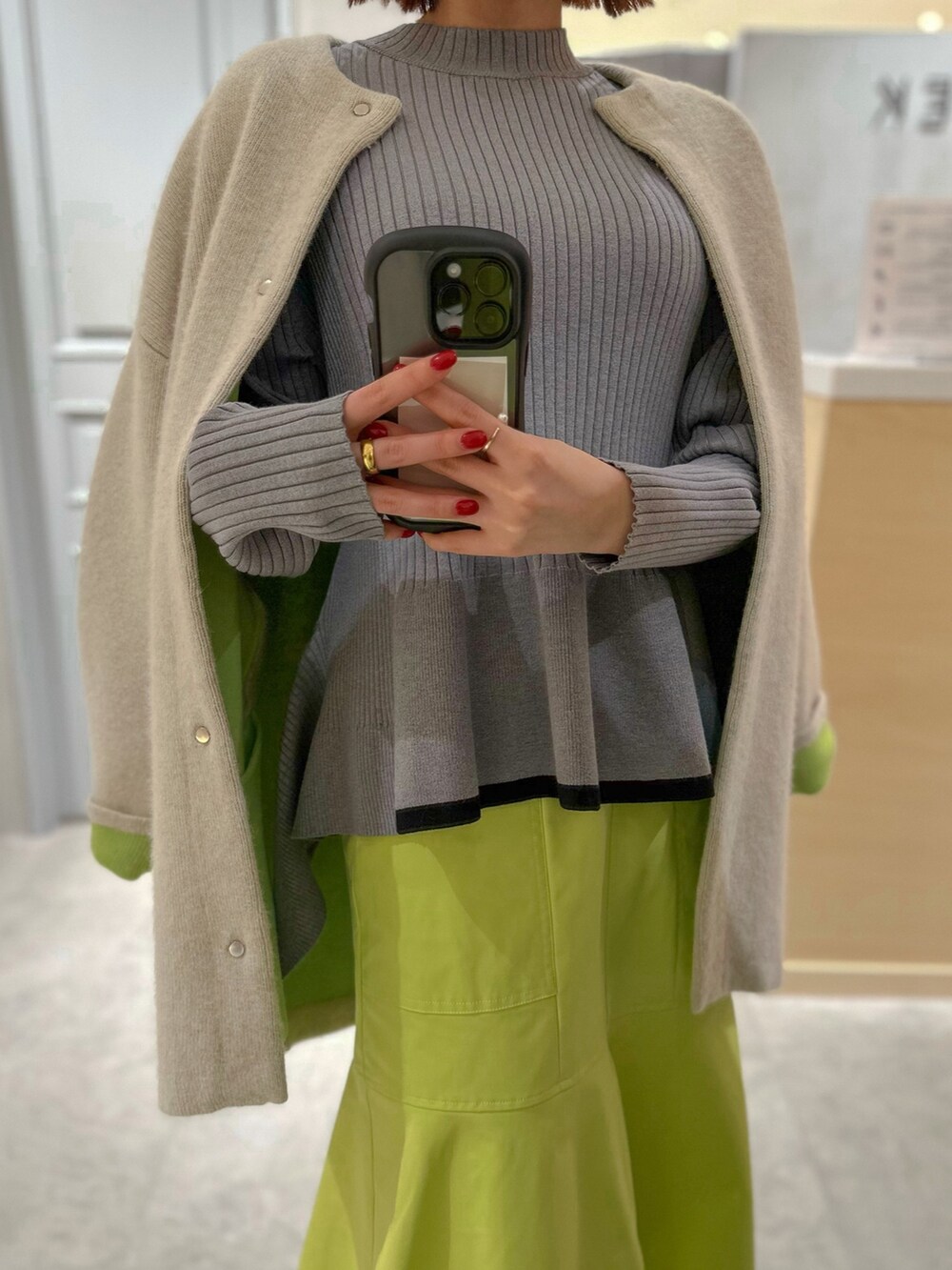 グレー系のニット/セーター、イエロー系のスカート、ホワイト系のスニーカーを着用したレディースの冬コーディネートの9枚目の写真