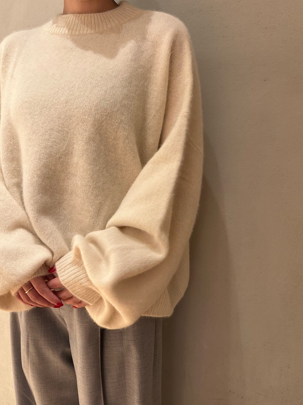 ホワイト系のニット/セーター、グレー系のその他パンツ、ブラック系のブーティを着用したレディースの秋コーディネートの4枚目の写真