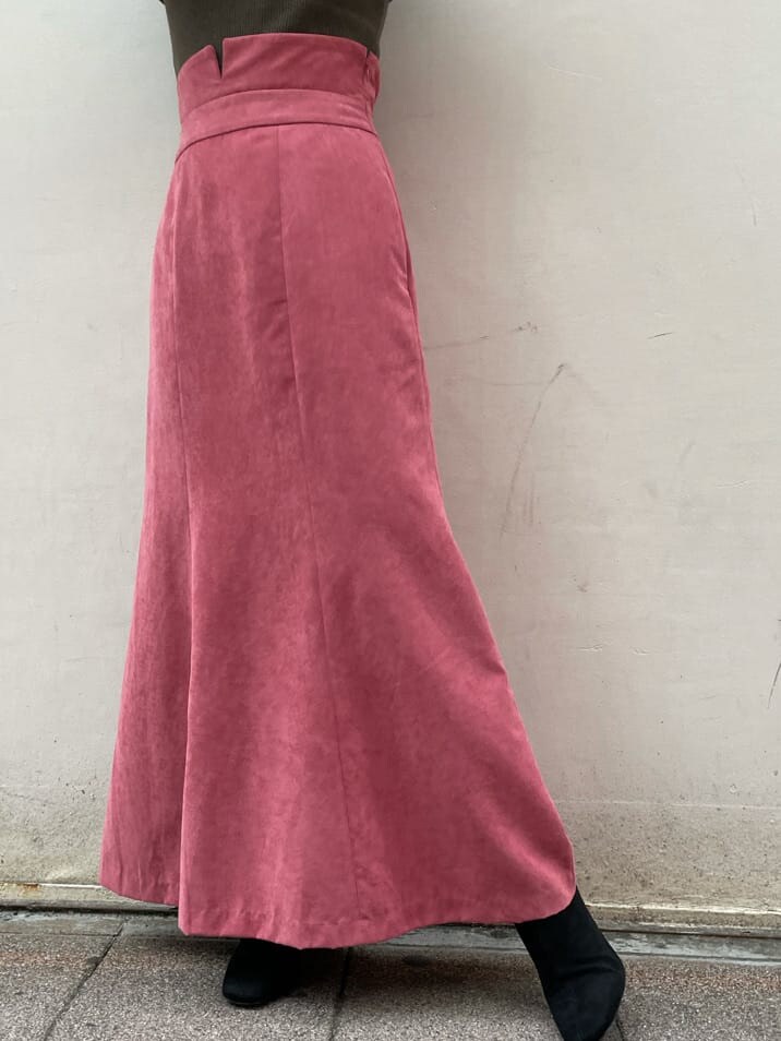 ブラック系のブーツ、ベージュ系のその他アウター、ピンク系のスカートを着用したレディースの秋コーディネートの6枚目の写真