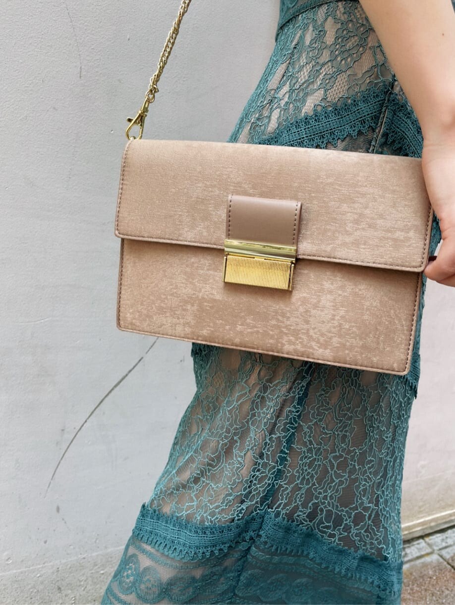 グリーン系のドレス、ベージュ系のパンプス、ブラウン系のクラッチバッグを着用したレディースの夏コーディネートの7枚目の写真