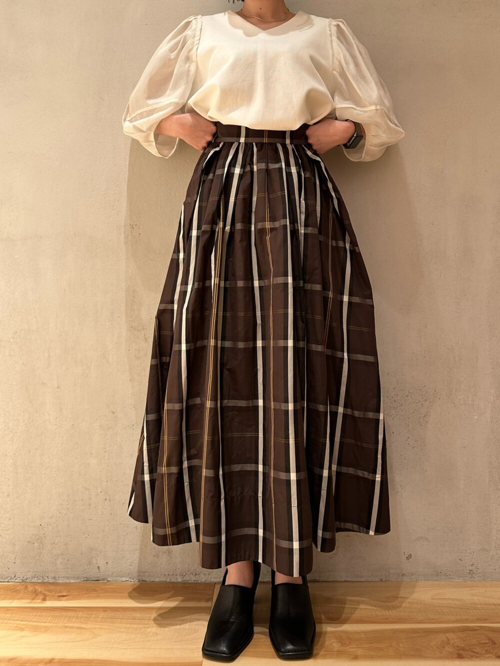 ホワイト系のTシャツ/カットソー、ブラウン系のスカート、ブラック系のパンプスを着用したレディースの春コーディネートの4枚目の写真