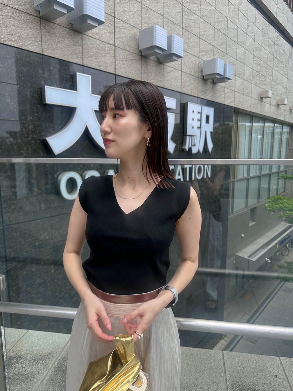 ブラック系のパンプス、ベージュ系のスカート、ブラック系のタンクトップを着用したレディースの夏コーディネートの5枚目の写真