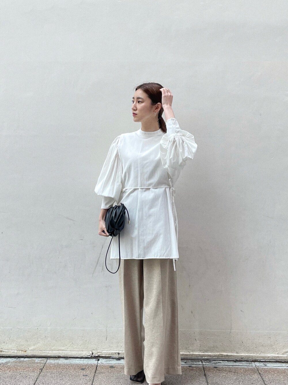 ホワイト系のシャツ/ブラウス、ブラック系のサンダル、ブラック系のハンドバッグを着用したレディースの春コーディネートの6枚目の写真