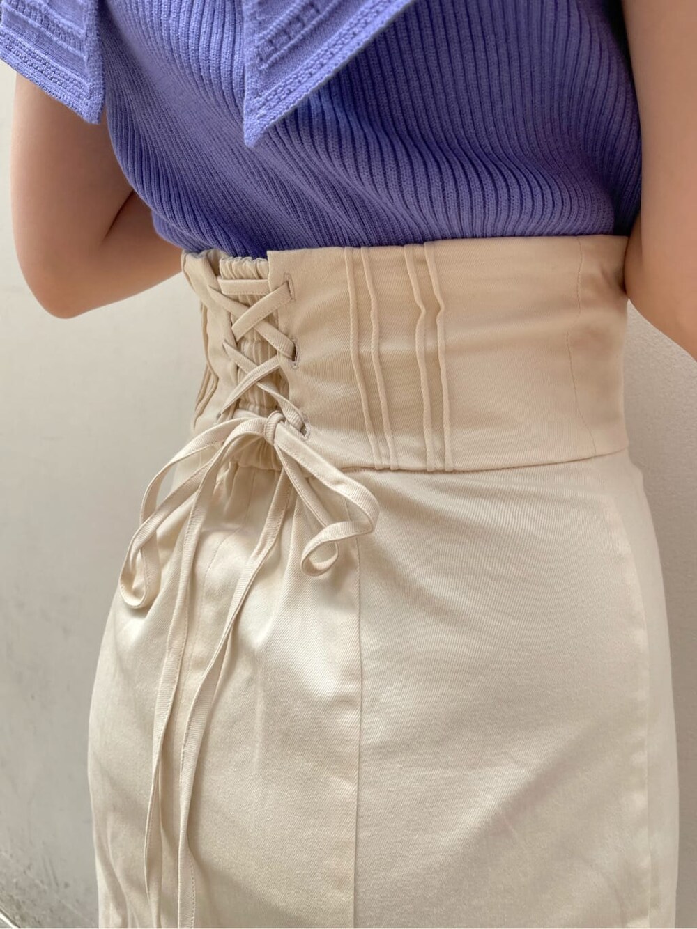 ホワイト系のスカート、その他のパンプス、パープル系のニット/セーターを着用したレディースの春コーディネートの6枚目の写真