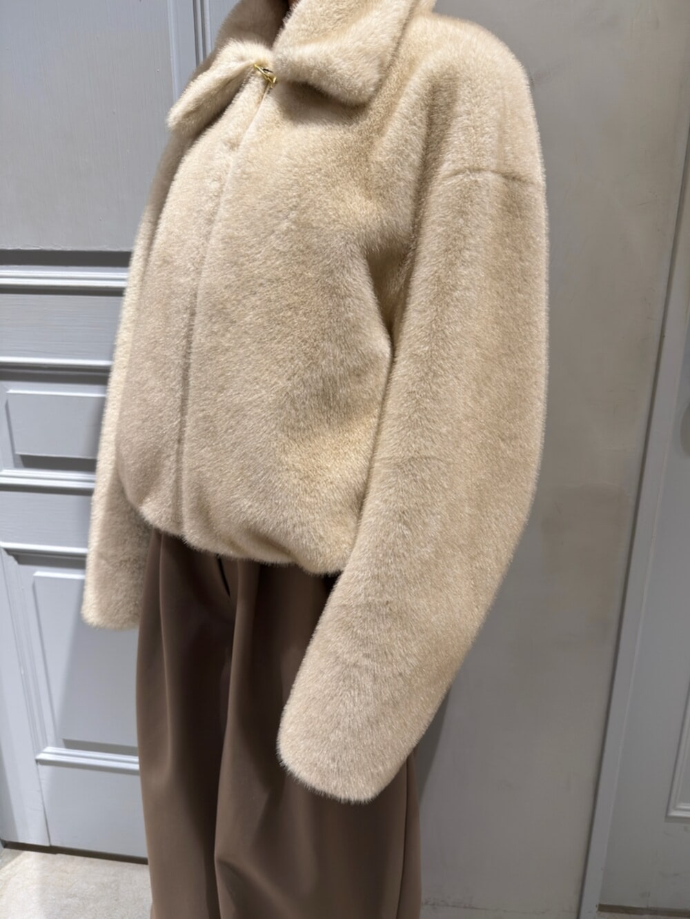 ベージュ系のブルゾン、ブラウン系のその他パンツを着用したレディースの冬コーディネートの4枚目の写真