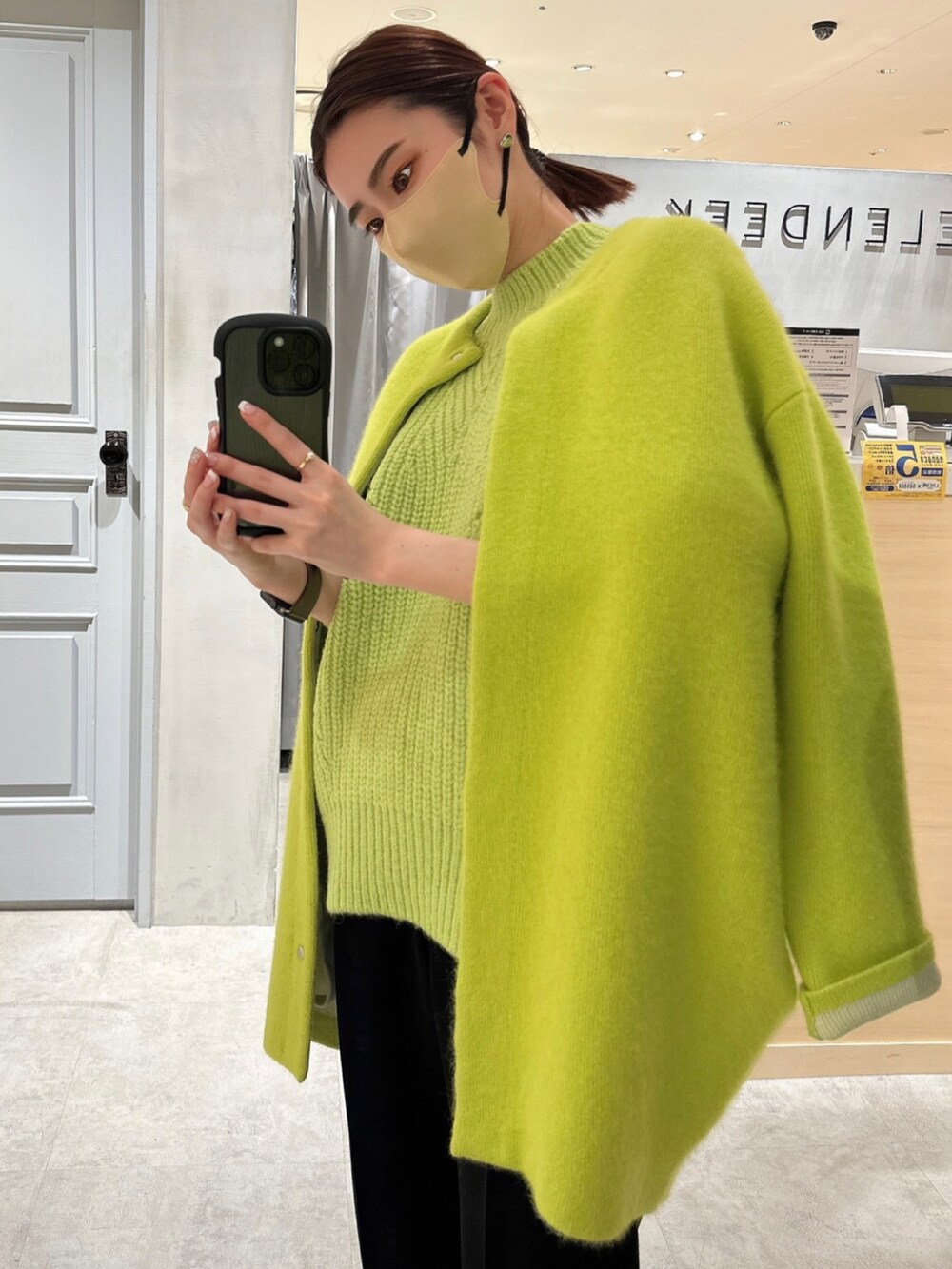 イエロー系のカーディガン/ボレロ、ブラック系のその他パンツ、グリーン系のニット/セーターを着用したレディースの冬コーディネートの6枚目の写真