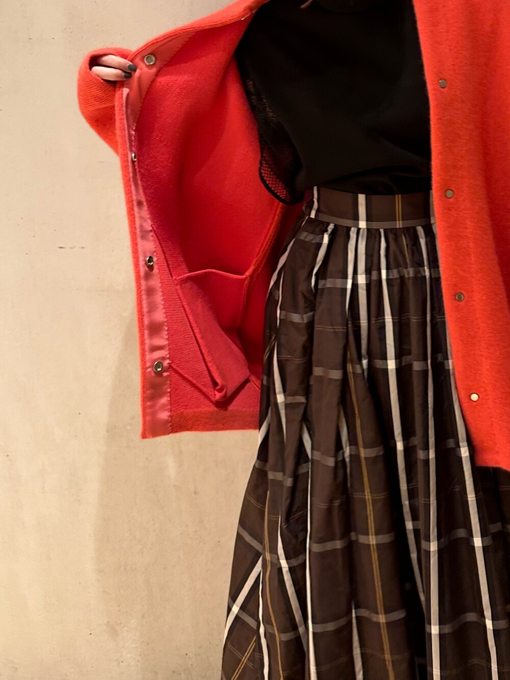 ピンク系のノーカラージャケット、ブラウン系のスカート、ブラック系のブーツを着用したレディースの夏コーディネートの7枚目の写真