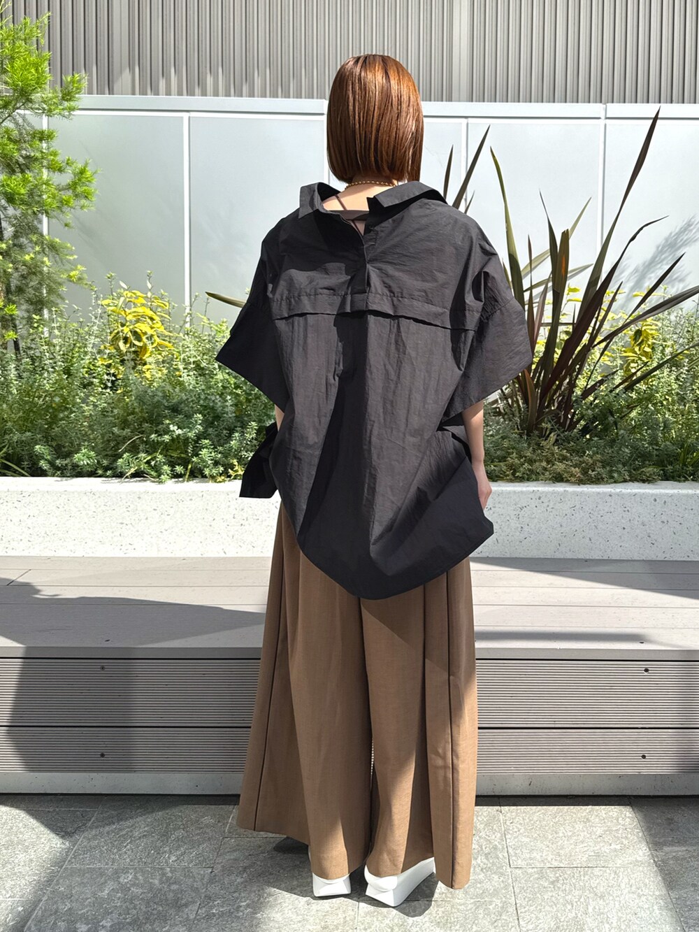 ブラック系のシャツ/ブラウス、ベージュ系のつなぎ/オールインワン、ホワイト系のサンダルを着用したレディースの春コーディネートの4枚目の写真