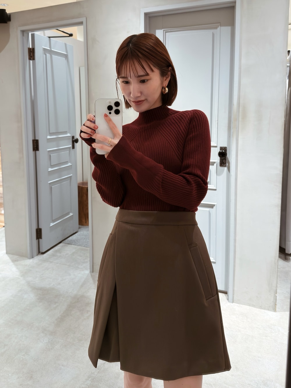 レッド系のニット/セーター、ブラウン系のその他パンツを着用したレディースの秋コーディネートの3枚目の写真