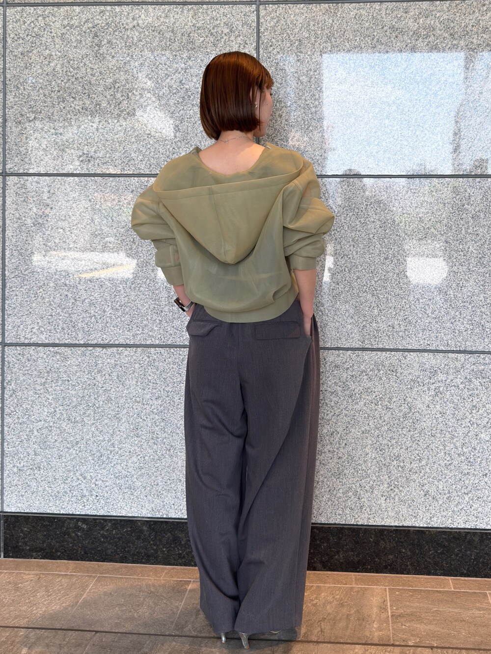 グリーン系のブルゾン、グレー系のその他パンツ、シルバー系のパンプスを着用したレディースの夏コーディネートの4枚目の写真