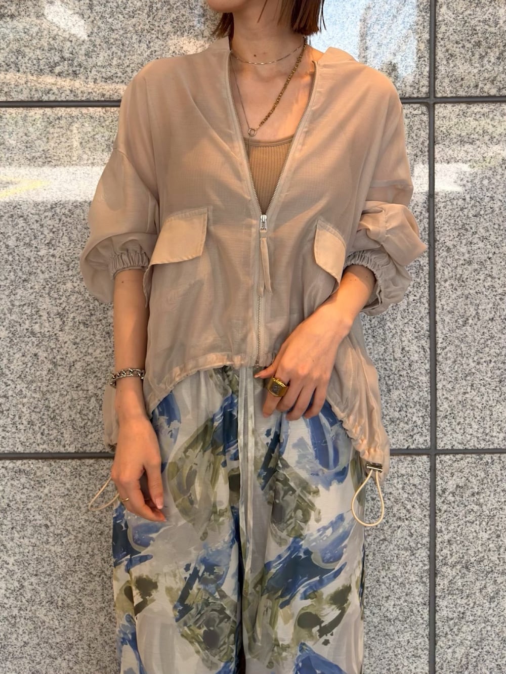 ベージュ系のブルゾン、ブルー系のその他パンツ、ブラウン系のサンダルを着用したレディースの春コーディネートの4枚目の写真