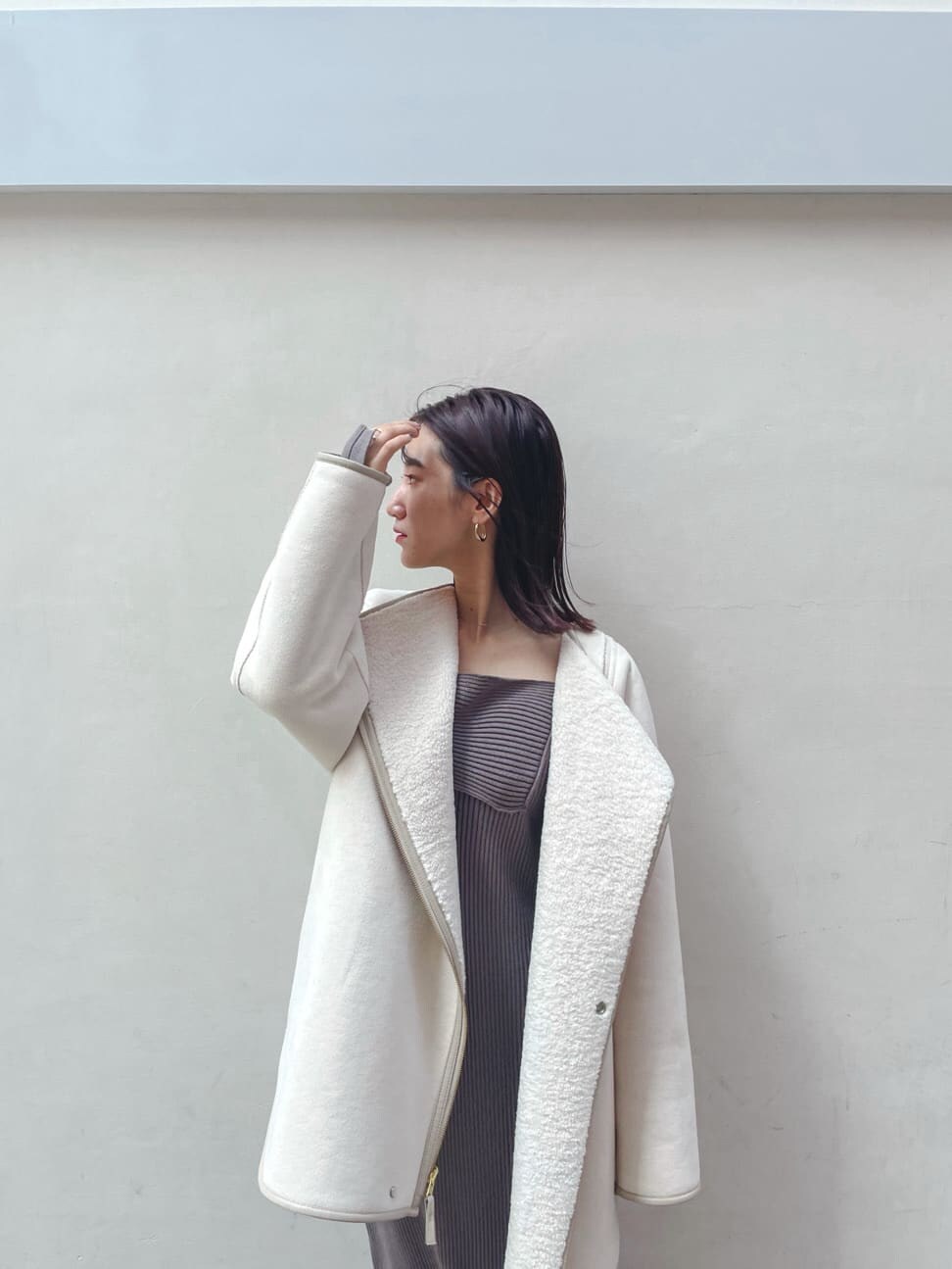 ブラック系のブーツ、ホワイト系のその他アウター、ベージュ系のワンピースを着用したレディースの秋コーディネートの8枚目の写真