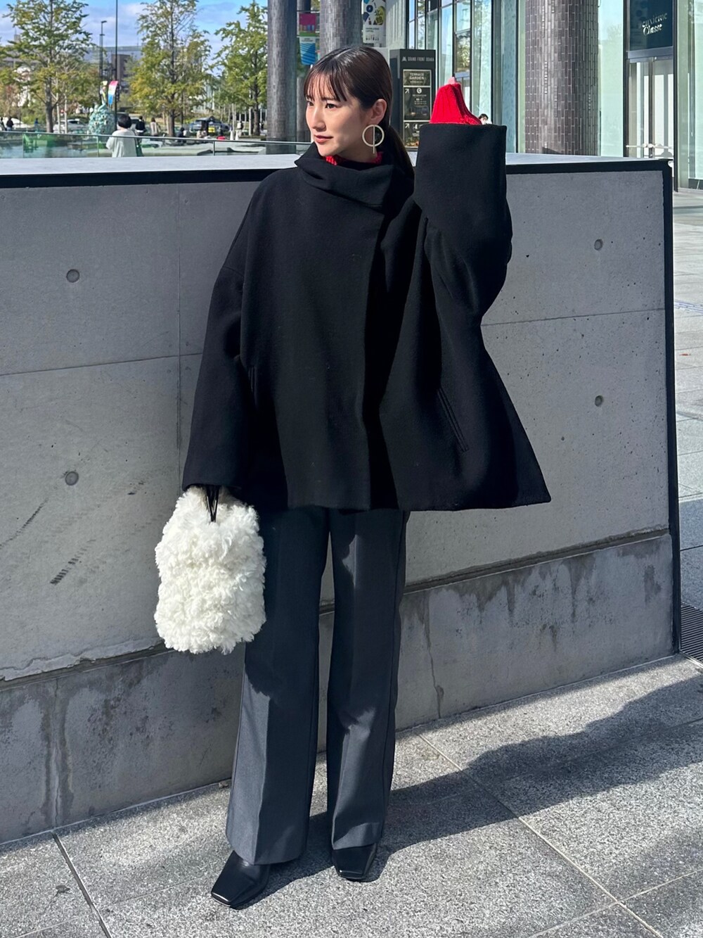 ブラック系のその他アウター、レッド系のニット/セーター、グレー系のその他パンツを着用したレディースの冬コーディネートの2枚目の写真