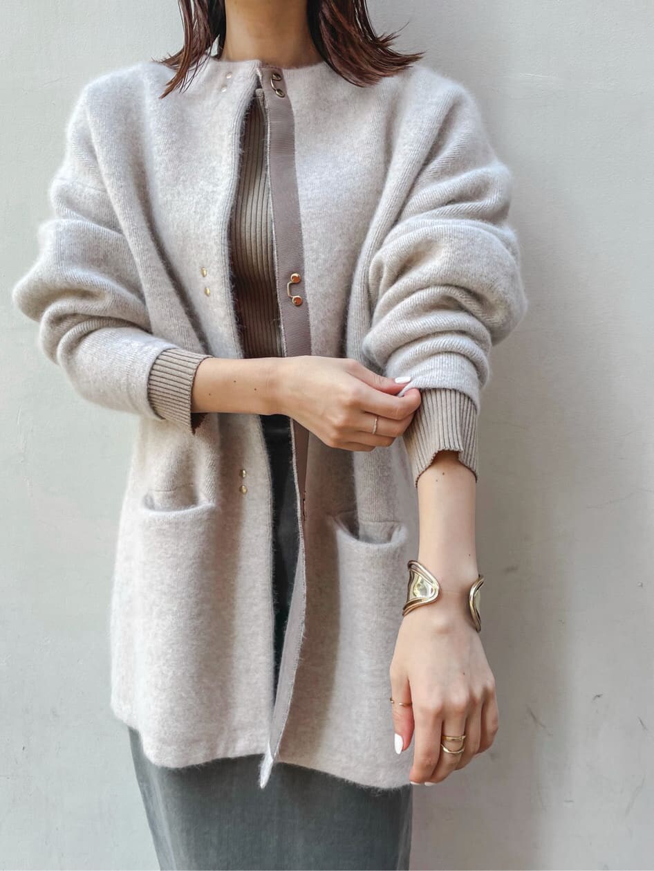 ブラック系のブーツ、ベージュ系のニット/セーター、グレー系のスカートを着用したレディースの秋コーディネートの4枚目の写真