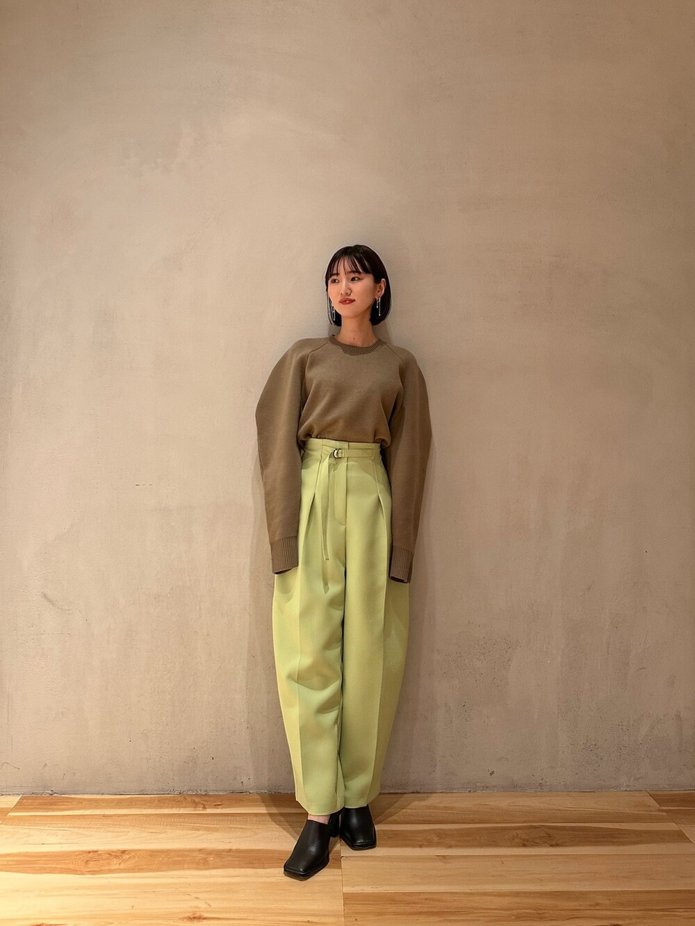 グリーン系のその他パンツ、ベージュ系のニット/セーター、ブラック系のブーティを着用したレディースの冬コーディネートの5枚目の写真