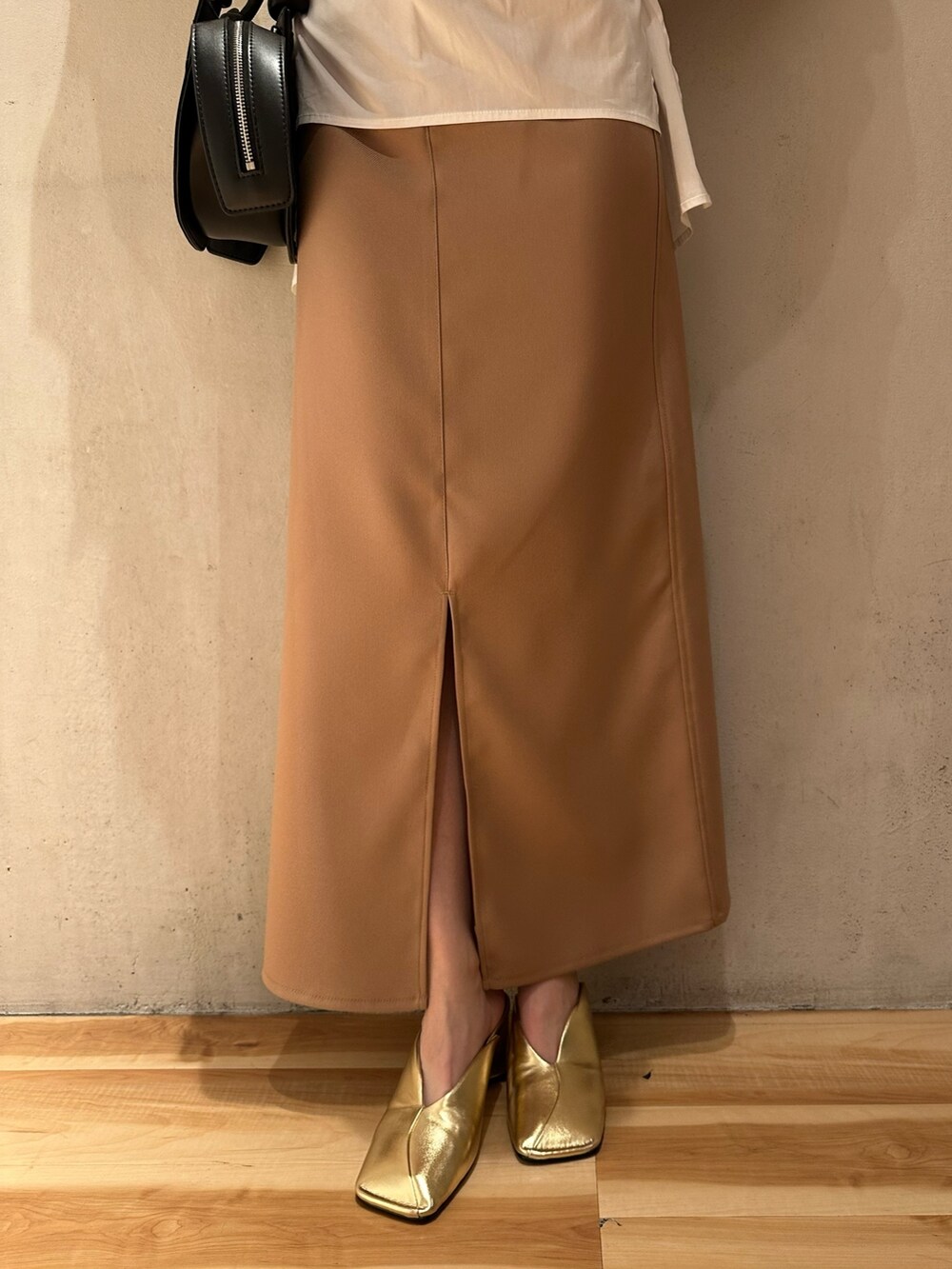 ホワイト系のシャツ/ブラウス、ベージュ系のスカート、ゴールド系のパンプスを着用したレディースの冬コーディネートの6枚目の写真