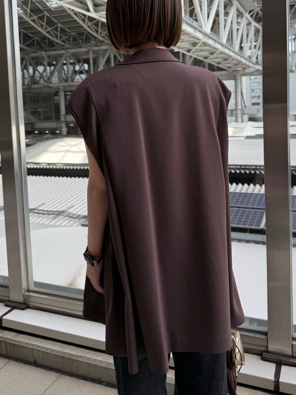 ブラウン系のテーラードジャケット、ブラック系のデニムパンツ、ブラウン系のショルダーバッグを着用したレディースの夏コーディネートの5枚目の写真