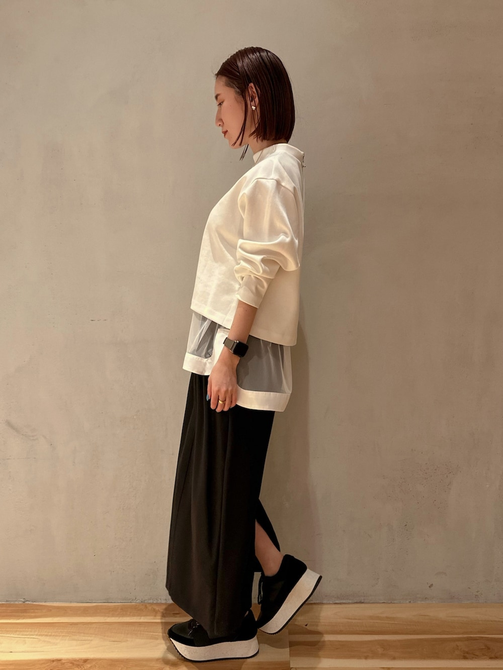 ホワイト系のTシャツ/カットソー、ブラック系のスカート、ブラック系のスニーカーを着用したレディースの冬コーディネートの2枚目の写真