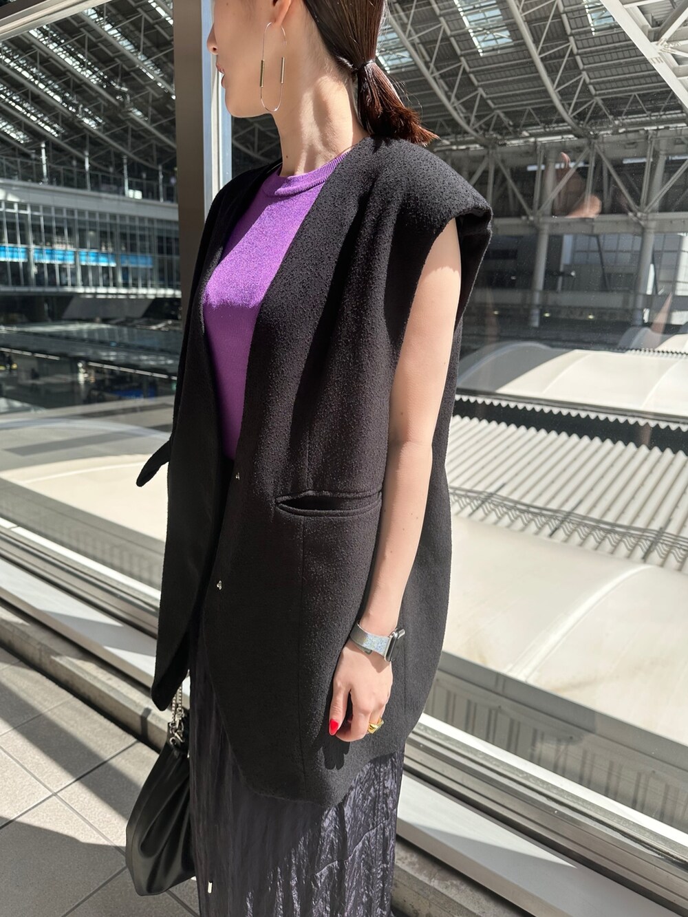 パープル系のニット/セーター、ブルー系のスカート、シルバー系のパンプスを着用したレディースの春コーディネートの6枚目の写真