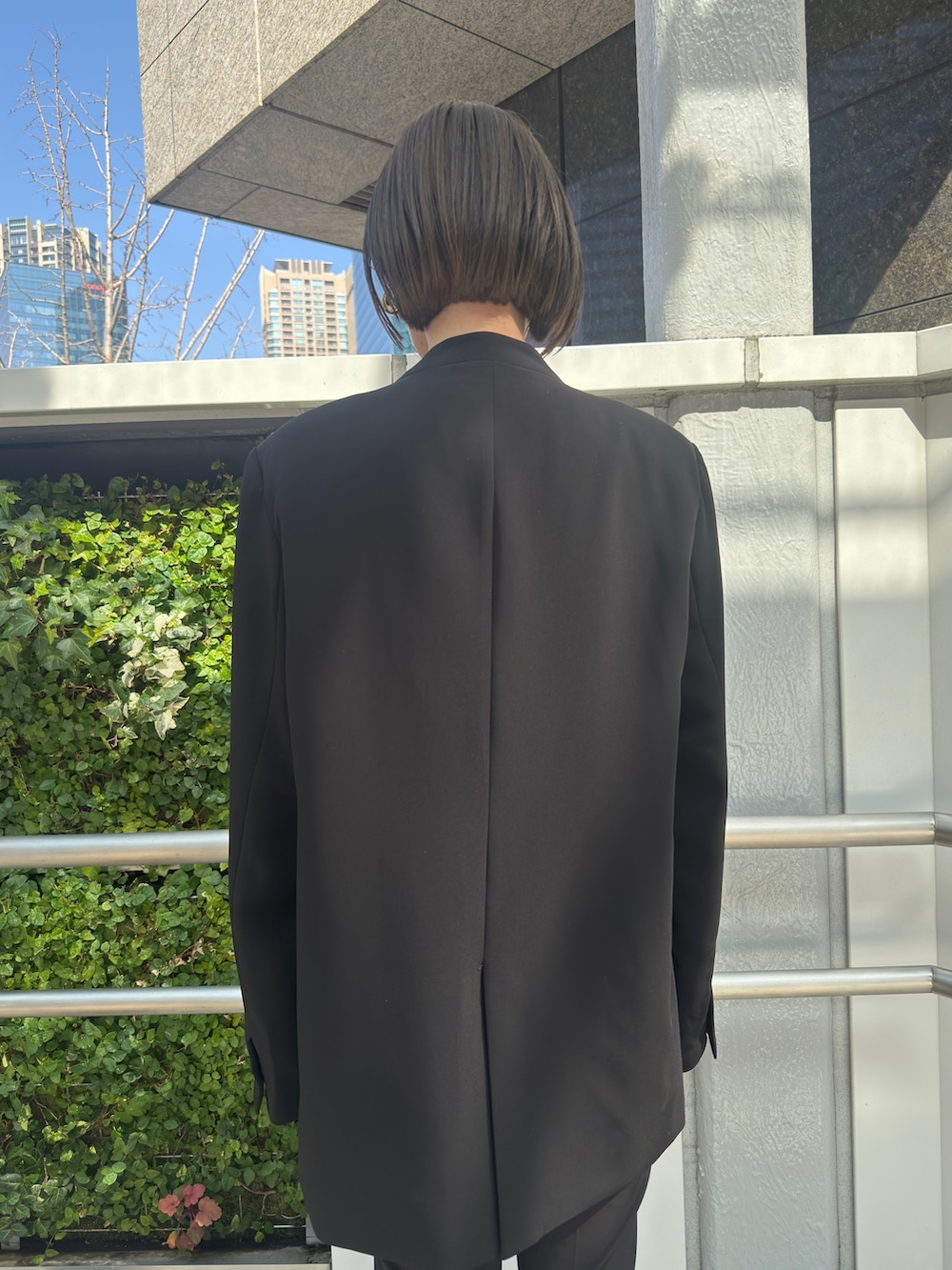 ブラック系のノーカラージャケット、ブラック系のその他パンツ、ブラック系のパンプスを着用したレディースの冬コーディネートの5枚目の写真