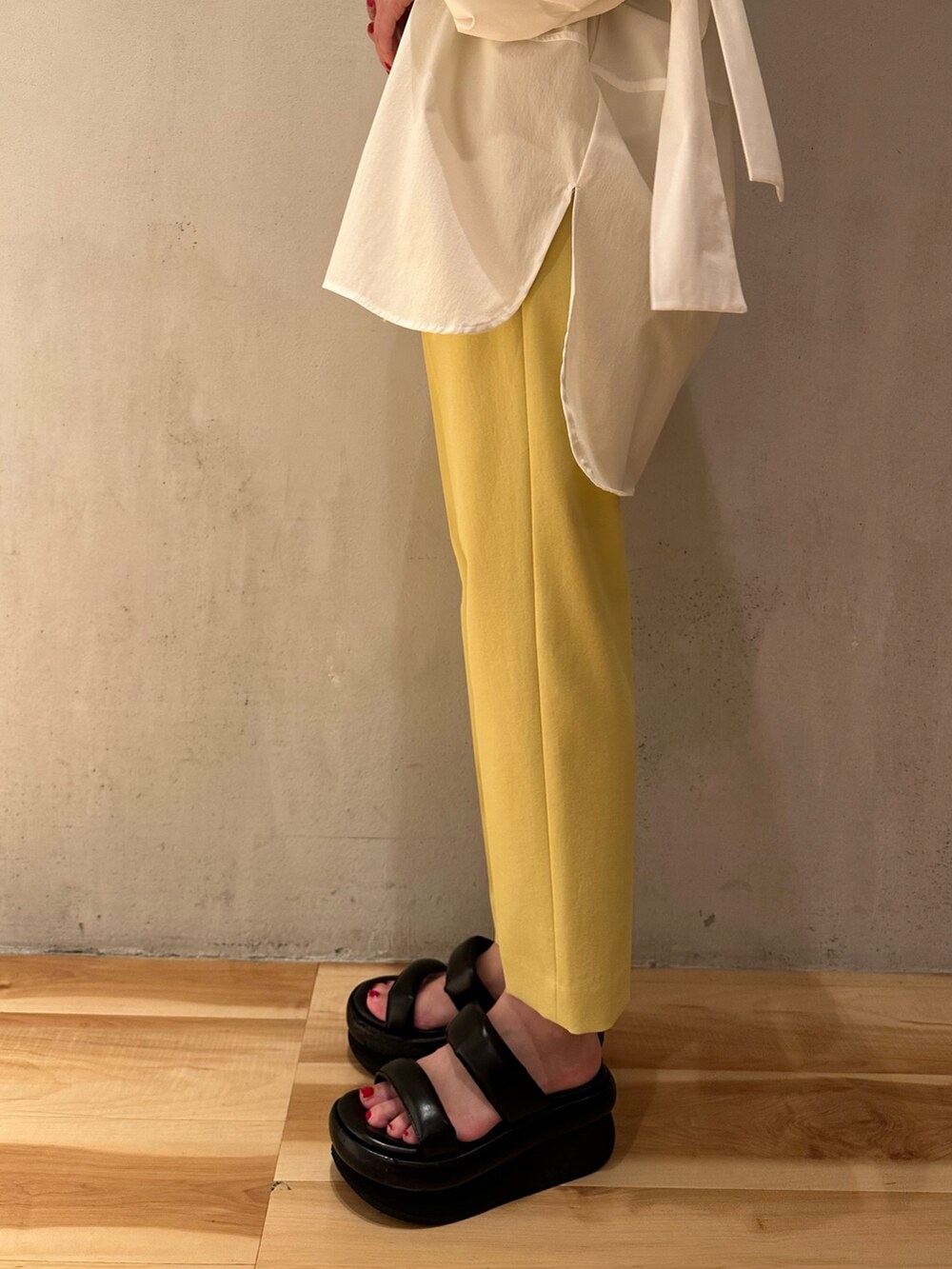 ホワイト系のシャツ/ブラウス、イエロー系のその他パンツ、ブラック系のサンダルを着用したレディースの夏コーディネートの6枚目の写真