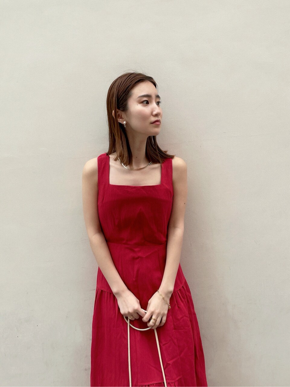 その他のパンプス、レッド系のワンピース、ベージュ系のテーラードジャケットを着用したレディースの春コーディネートの2枚目の写真