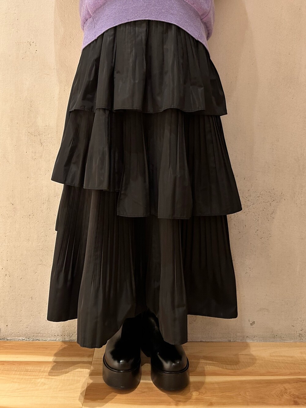 ブラック系のスカート、ホワイト系のノーカラージャケット、パープル系のニット/セーターを着用したレディースの夏コーディネートの5枚目の写真