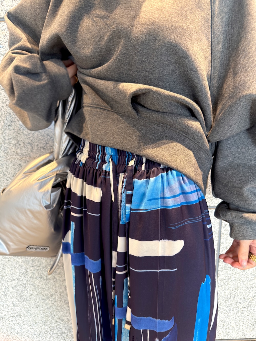 グレー系のTシャツ/カットソー、シルバー系のハンドバッグ、ブルー系のその他パンツを着用したレディースの冬コーディネートの8枚目の写真