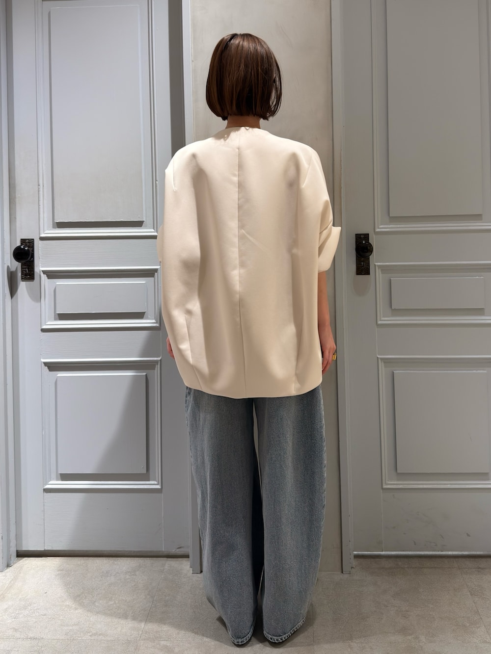 ベージュ系のその他アウター、ブルー系のデニムパンツ、シルバー系のパンプスを着用したレディースの春コーディネートの4枚目の写真