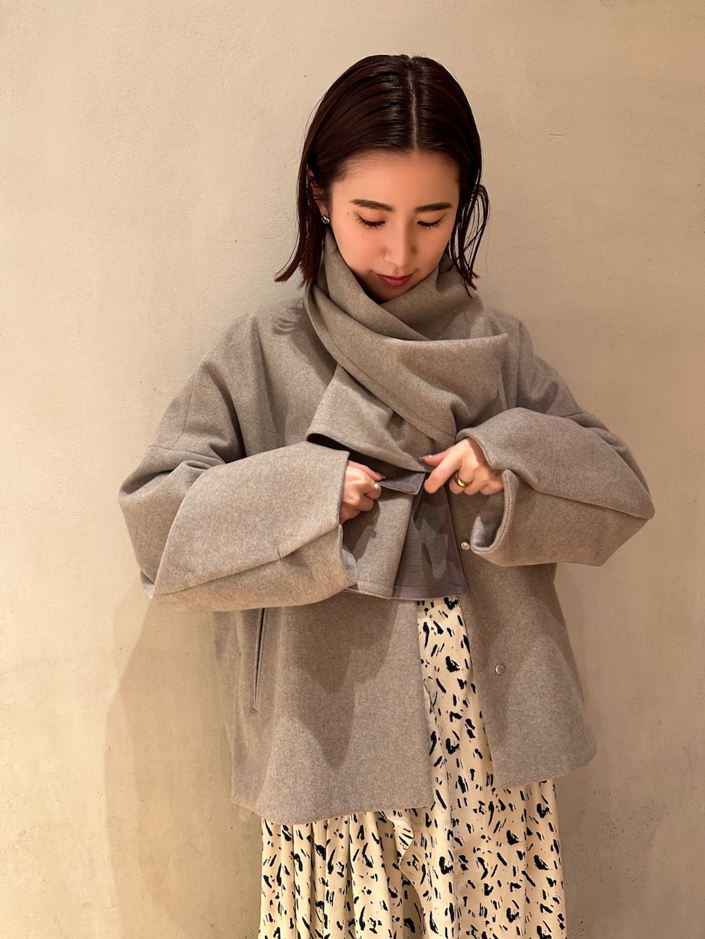 グレー系のステンカラーコート、その他のワンピースを着用したレディースの冬コーディネートの4枚目の写真