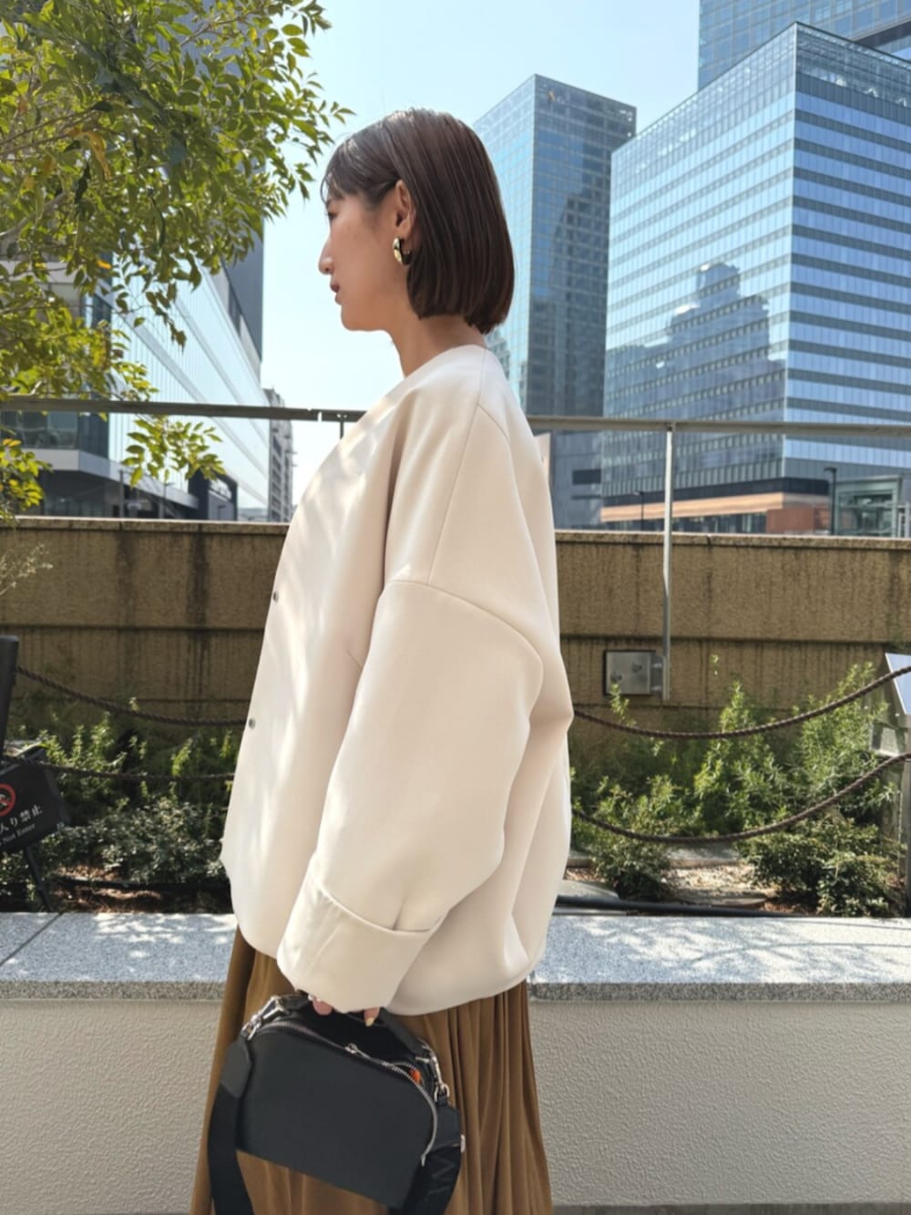 シルバー系のサンダル、ブラウン系のワンピース、ベージュ系のその他アウターを着用したレディースの春コーディネートの4枚目の写真