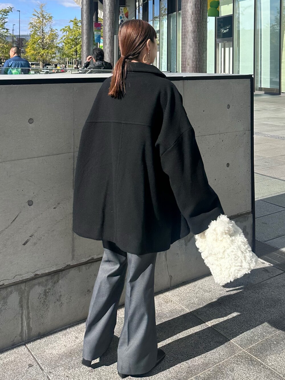 ブラック系のその他アウター、レッド系のニット/セーター、グレー系のその他パンツを着用したレディースの冬コーディネートの3枚目の写真