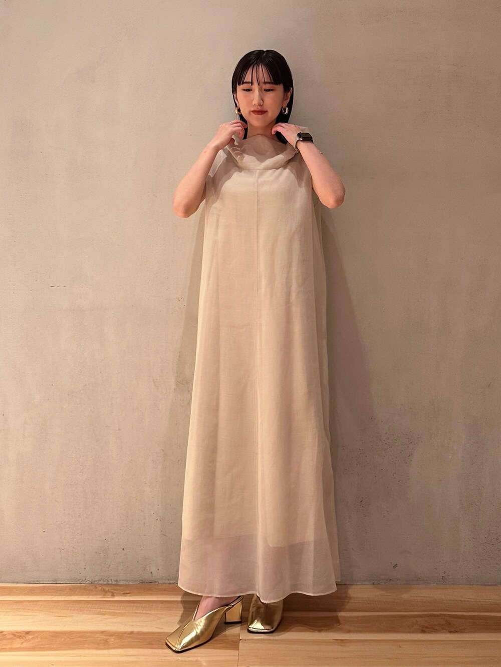 ベージュ系のワンピース、ゴールド系のパンプスを着用したレディースの夏コーディネートの3枚目の写真