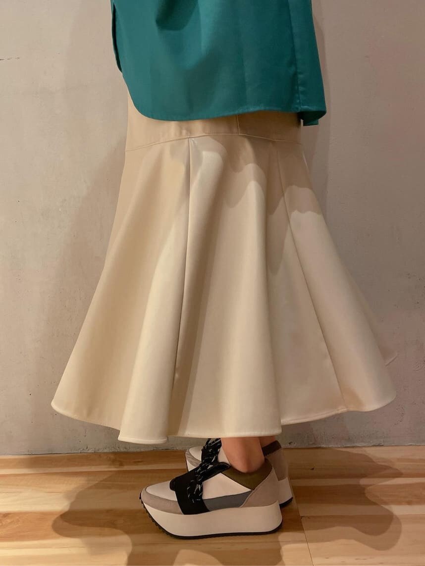 ベージュ系のスカート、ブルー系のスニーカー、グリーン系のシャツ/ブラウスを着用したレディースの秋コーディネートの6枚目の写真