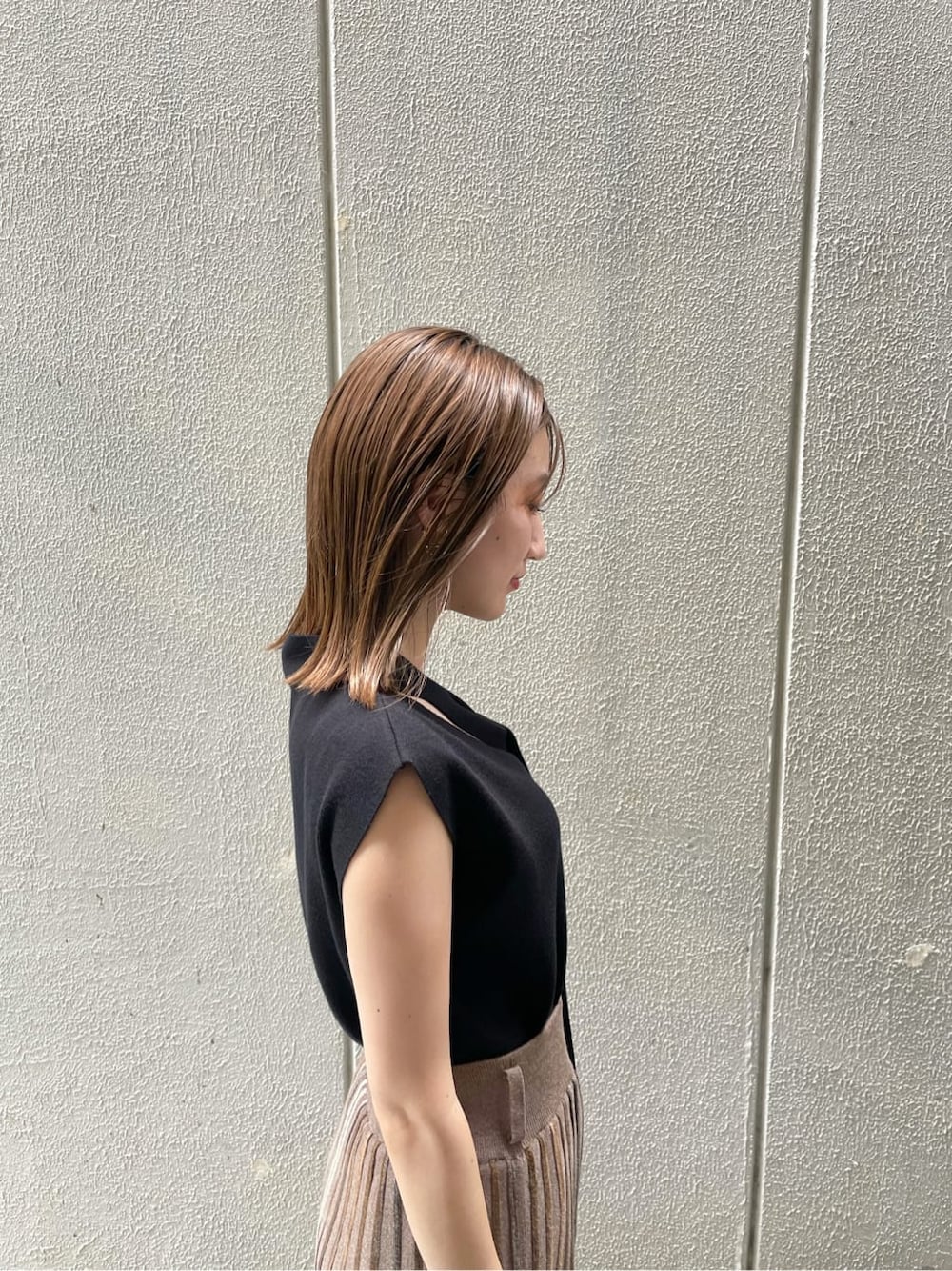 ブラウン系のスカート、ブラック系のニット/セーター、ブラウン系のサンダルを着用したレディースの夏コーディネートの3枚目の写真