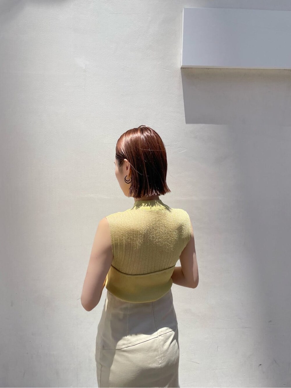 その他のパンプス、イエロー系のニット/セーター、ベージュ系のスカートを着用したレディースの夏コーディネートの6枚目の写真