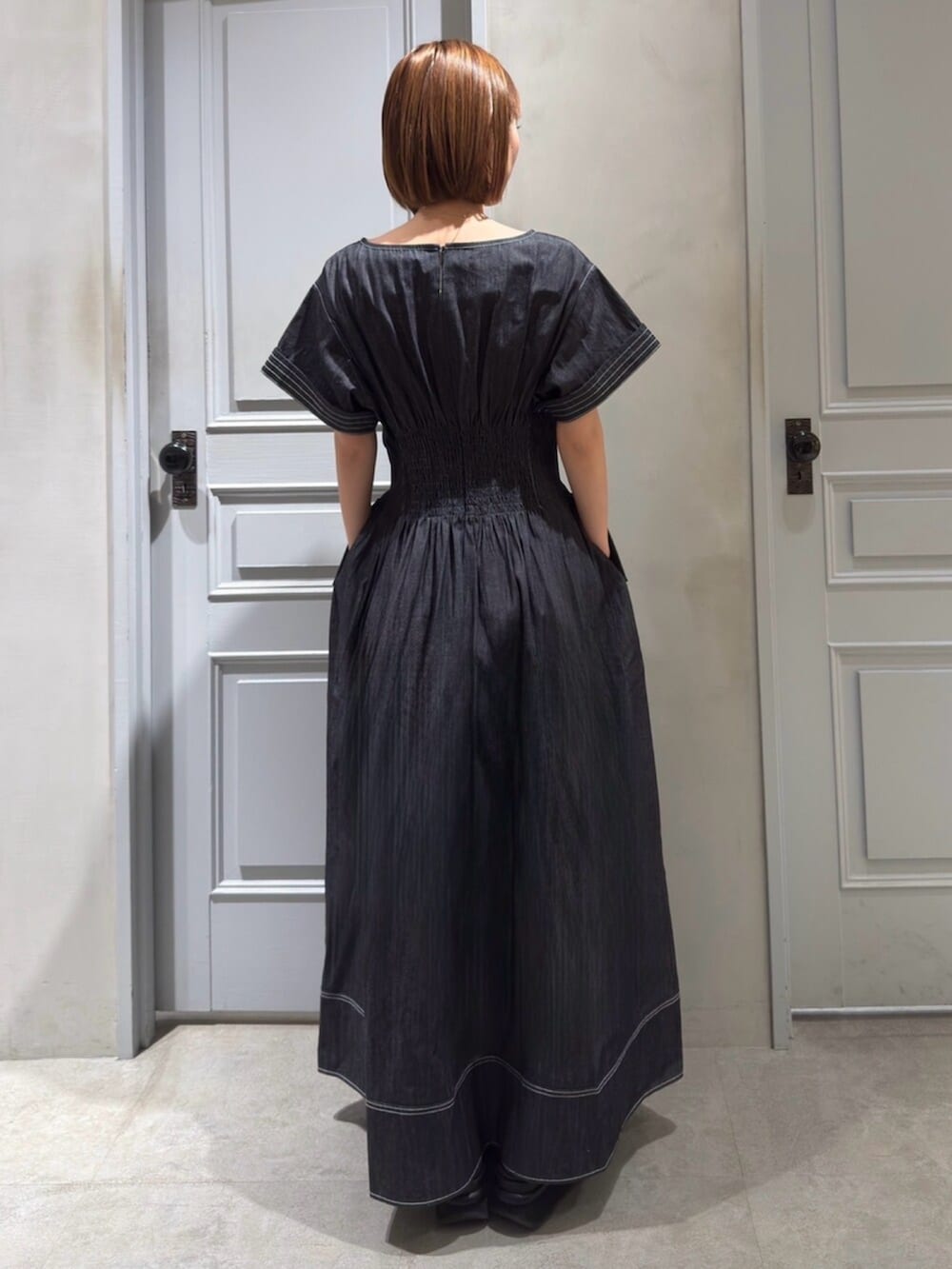 ブルー系のワンピース、ブラック系のサンダルを着用したレディースの春コーディネートの2枚目の写真