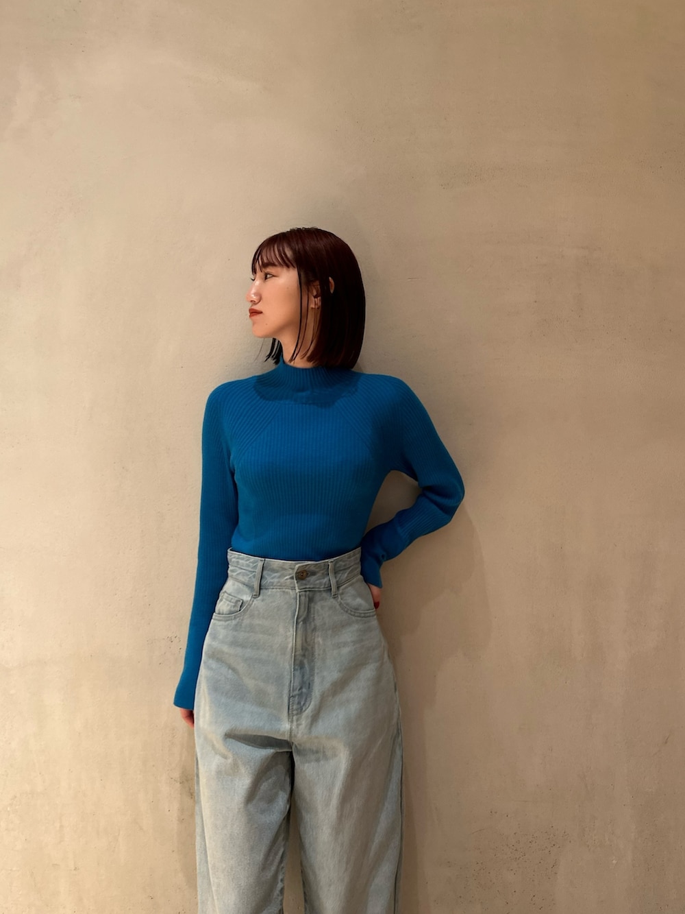 ブラック系のノーカラージャケット、ブルー系のニット/セーター、ブルー系のデニムパンツを着用したレディースの夏コーディネートの7枚目の写真