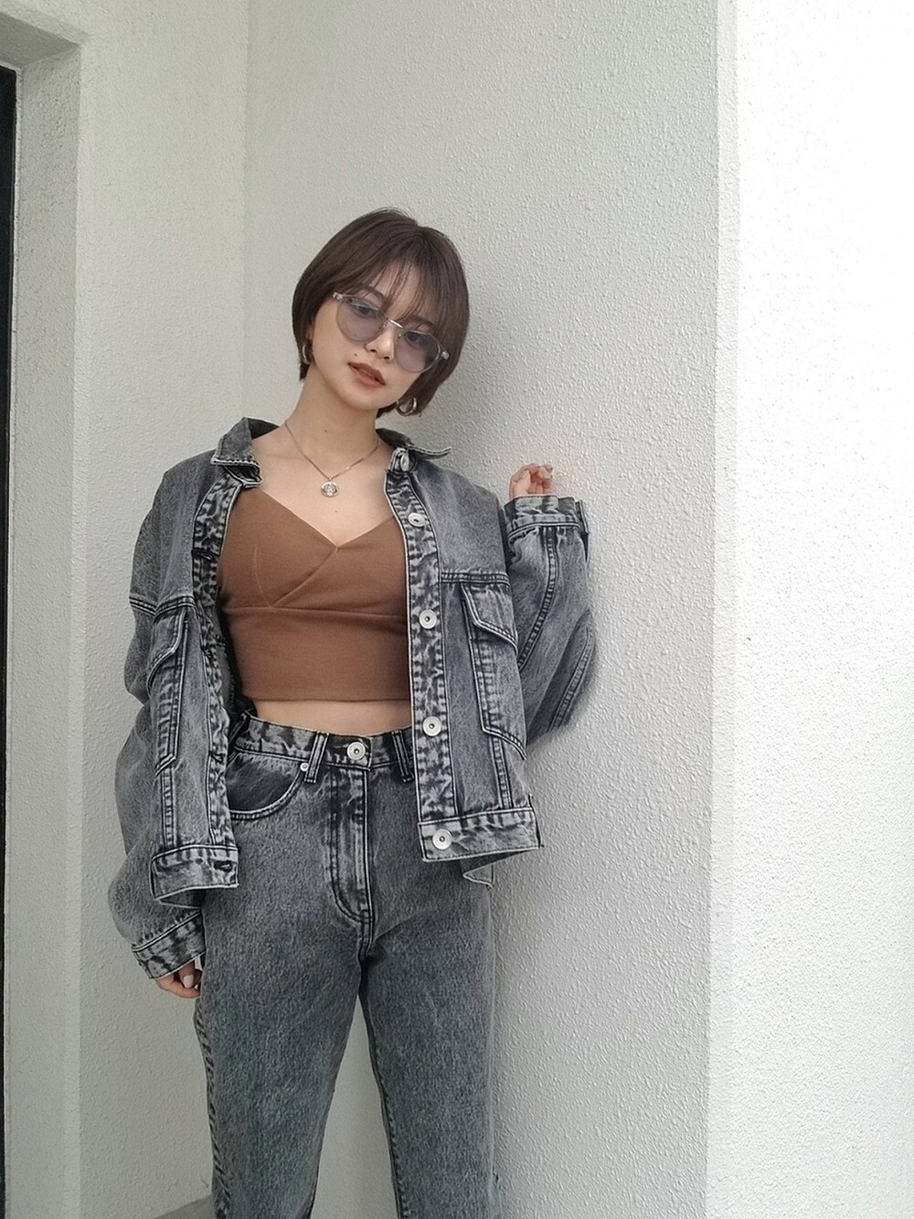 ブラック系のデニムパンツ、ブラウン系のキャミソールを着用したレディースの夏コーディネートの3枚目の写真