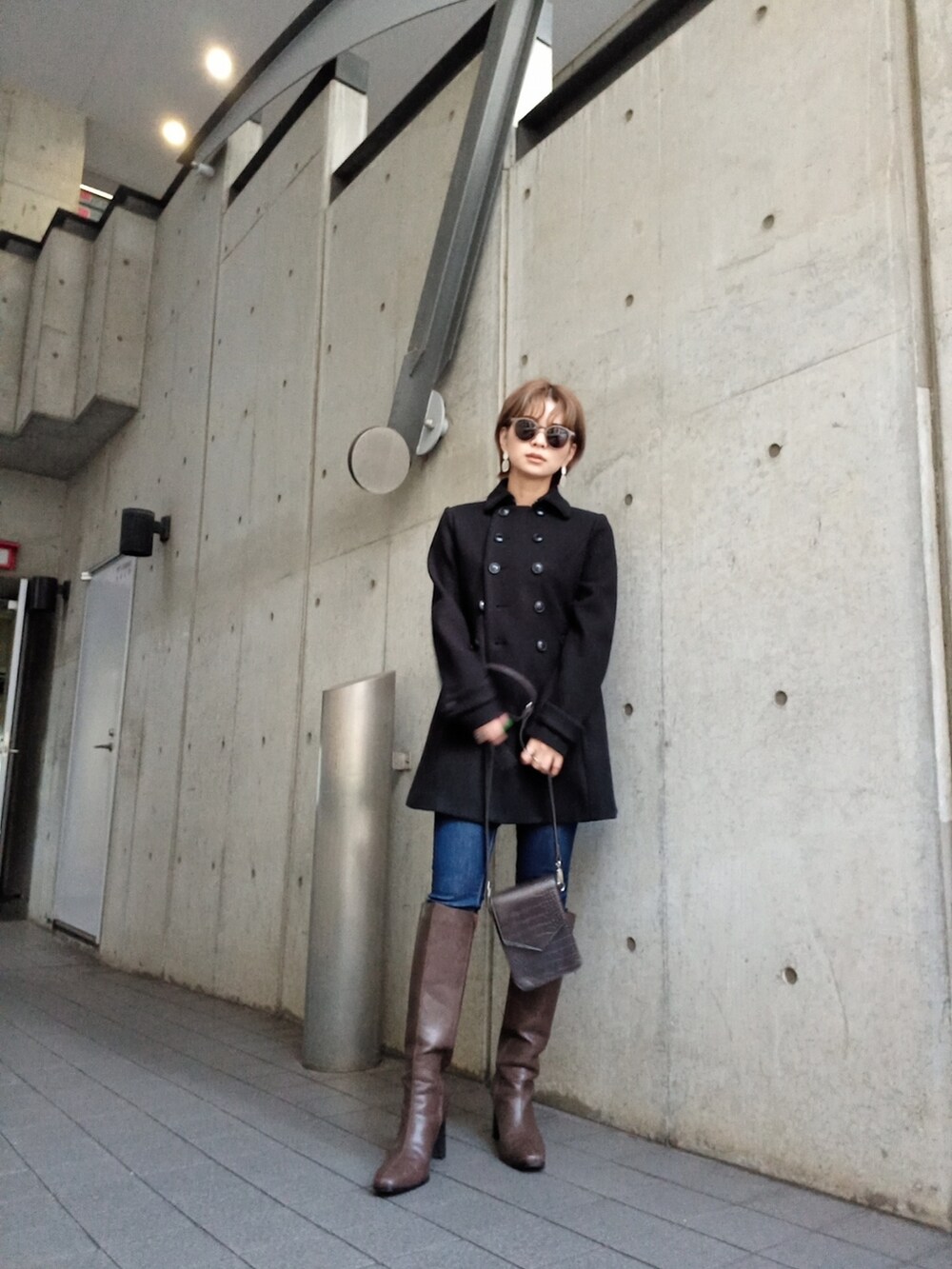 ブラウン系のブーツ、ブラウン系のショルダーバッグを着用したレディースの秋コーディネートの4枚目の写真