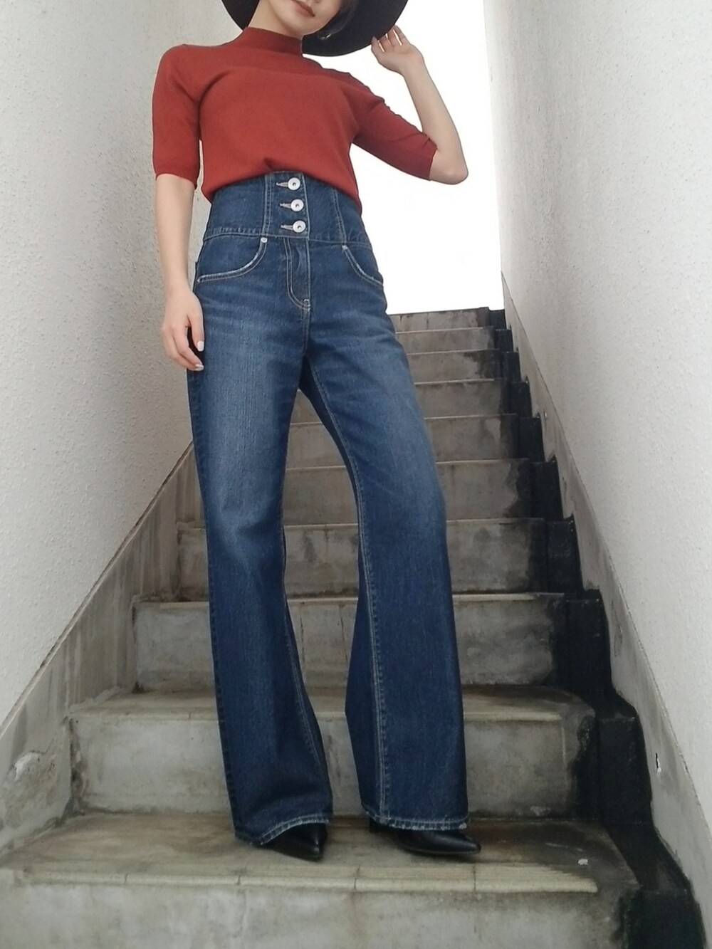 オレンジ系のニット/セーター、ブラウン系のハットを着用したレディースの夏コーディネートの5枚目の写真